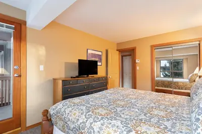 a bedroom with a bed and a tv on a dresser at Symphony by Whistler Premier in Whistler