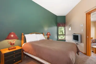 a bedroom with a bed and a television at Symphony by Whistler Premier in Whistler