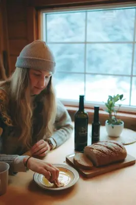 a woman sitting at a table with a plate of food at Little Atlin Lodge in Tagish