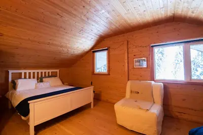 a bedroom with two beds in a log cabin at Little Atlin Lodge in Tagish