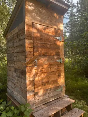a wooden out house sitting on a bench at Little Atlin Lodge in Tagish