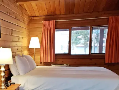 a bedroom with a white bed and two windows at Rocky Inn in Valemount