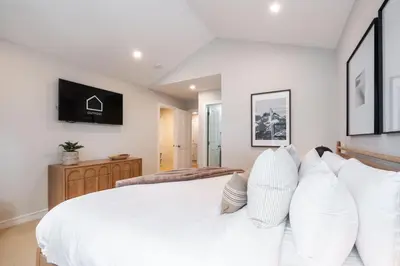 a bedroom with a white bed with white pillows at The Woods by Outpost Whistler in Whistler