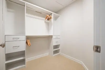 a white walk in closet with white cabinets at The Woods by Outpost Whistler in Whistler