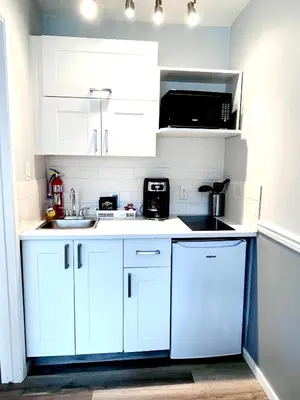 a kitchen with white cabinets and a sink and a microwave at The Orchard at Oliver in Oliver