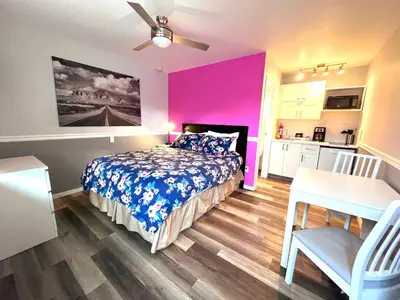 a bedroom with a bed and a pink wall at The Orchard at Oliver in Oliver