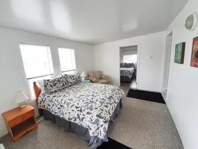 a bedroom with a bed and a chair in it at The Orchard at Oliver in Oliver