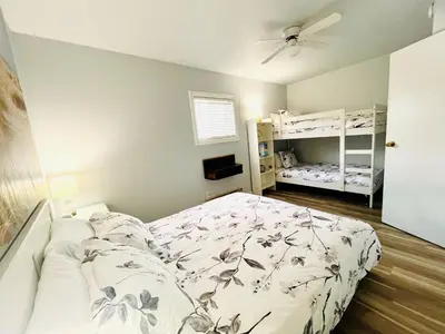 a bedroom with a bed and two bunk beds at The Orchard at Oliver in Oliver