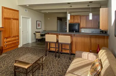 a living room with a couch and a kitchen at Fairways Hotel on the Mountain in Victoria