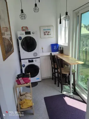 a kitchen with a table and a washer and dryer at Sweet House B&B in Victoria