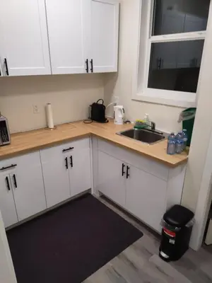 a kitchen with white cabinets and a sink at Sweet House B&B in Victoria