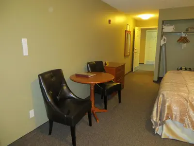 a hotel room with a table and two chairs and a bed at Village Creek Country Inn in Westerose