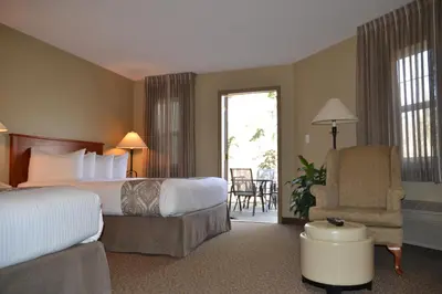 a hotel room with a bed and a chair at Village Creek Country Inn in Westerose