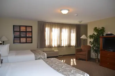 a hotel room with two beds and a television at Village Creek Country Inn in Westerose