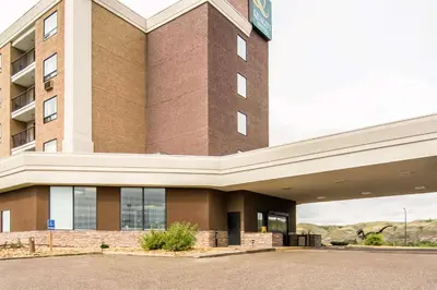 a large brick building with a sign on it at Quality Hotel in Drumheller