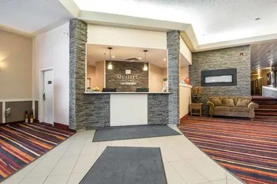 a lobby of a hotel with a couch and a bar at Quality Hotel in Drumheller