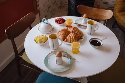 a white table with breakfast foods on it at eARTh studios GallerySuite in Nelson