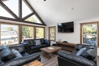 a living room with leather couches and a tv at Summit View in Valemount