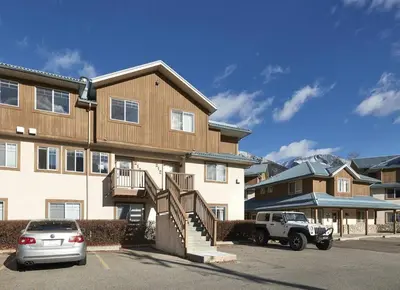 a truck parked in front of a large building at Mountain Gate - Pet Friendly 2BR w Mountain Views and open hot tub in Canmore