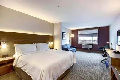 a hotel room with a large bed and a desk at Holiday Inn Express & Suites - Calgary Airport Trail NE by IHG in Calgary