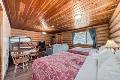 a bedroom with two beds and a table and a chair at Terracana Ranch Resort in Tete Jaune Cache