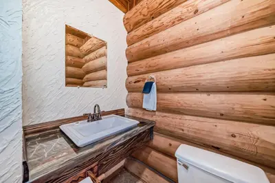 a bathroom with a sink in a wooden wall at Terracana Ranch Resort in Tete Jaune Cache