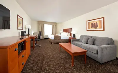 a hotel room with a bed and a couch and a room at Gold Eagle Lodge in North Battleford