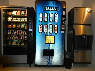 a drink vending machine next to a refrigerator at Gold Eagle Lodge in North Battleford