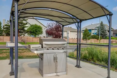a barbecue grill under a canopy in a park at Motel 6 Brooks AB in Brooks