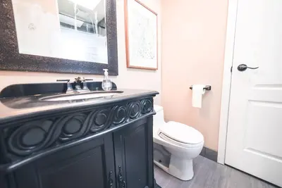 a bathroom with a black sink and a toilet at Corkscrew Willow Estate in Vancouver