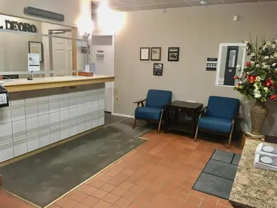 a waiting room with two blue chairs and a counter at Hotel Deoro in Lillooet