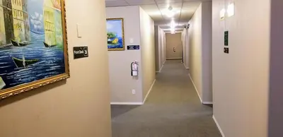 a hallway in a hospital with paintings on the walls at Hotel Deoro in Lillooet