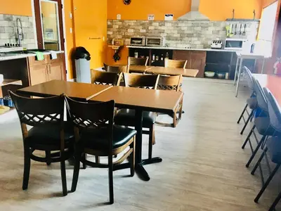 a dining room with a wooden table and chairs at Hotel Deoro in Lillooet