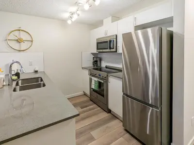 a kitchen with a stainless steel refrigerator and appliances at GlobalStay Cranbrook Townhome Suites in Calgary
