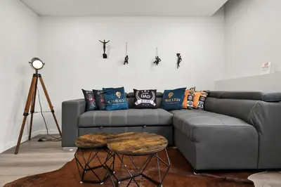 a living room with a gray couch and a table at GlobalStay Cranbrook Townhome Suites in Calgary
