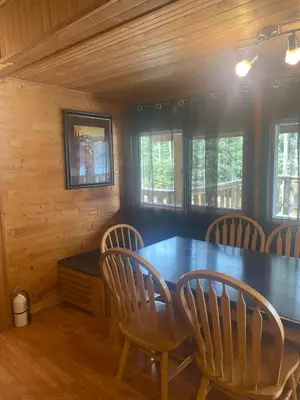 a dining room with a wooden table and chairs at Lac Des Roches Resort in Bridge Lake