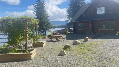 a backyard with a wooden cabin and a picnic table at Lac Des Roches Resort in Bridge Lake