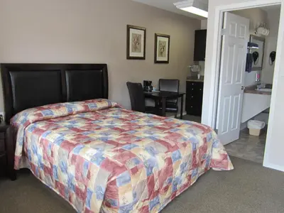 a bedroom with a bed and a table and a kitchen at Monte Carlo Motel in Barrière