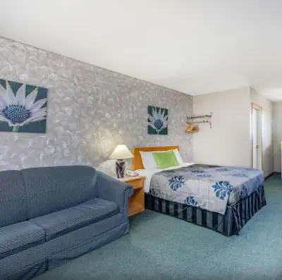 a hotel room with a bed and a couch at Almada Inn in Fort Nelson