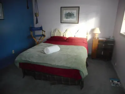 a bedroom with a large bed with red pillows at Queen, walk to village center in Whitehorse