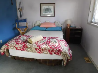 a bedroom with a bed with a red and white blanket at Queen, walk to village center in Whitehorse