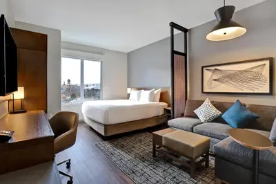 a hotel room with a bed and a couch at Hyatt Place Prince George in Prince George
