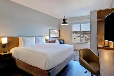 a hotel room with a large bed and a television at Hyatt Place Prince George in Prince George