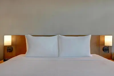 a bed with two white pillows on top of it at Hyatt Place Prince George in Prince George