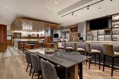 a restaurant with tables and chairs and a bar at Hyatt Place Prince George in Prince George