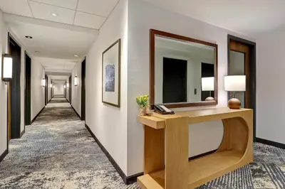 a hallway in a hotel with a mirror on a wall at Hyatt Place Prince George in Prince George