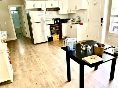 a kitchen with a black table and a refrigerator at Deluxe House in Surrey