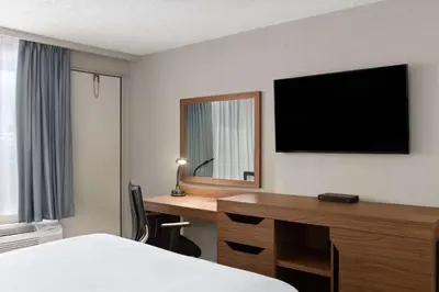 a hotel room with a desk and a television at Baymont by Wyndham Edson in Edson