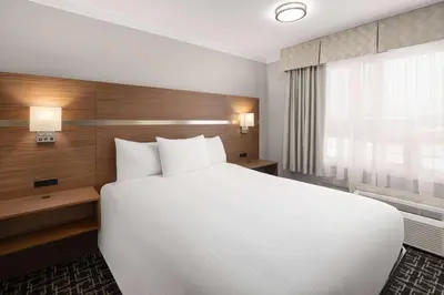a hotel room with a large bed and a window at Baymont by Wyndham Edson in Edson