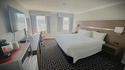 a hotel room with a large bed and a desk at Baymont by Wyndham Edson in Edson